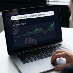 밝은 배경, 노트북에 실시간 승률 검색과 대시보드가 보이고 집중한 사용자가 앉아있는 모습이다